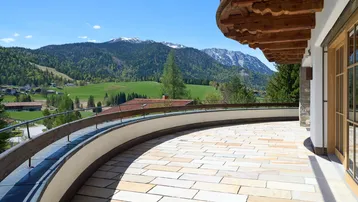 Weitläufige Terrasse mit Steinplatten und Panoramablick auf die umliegende Bergwelt.