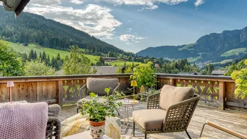 Geräumige Terrasse mit bequemen Sitzgelegenheiten und atemberaubendem Blick auf die umliegende Berglandschaft.