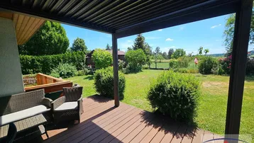 Überdachte Terrasse mit bequemen Gartenmöbeln und weitem Blick ins Grüne.