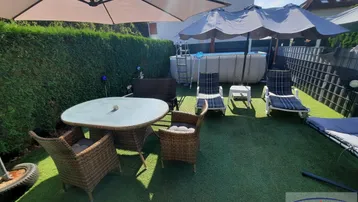 Gemütlicher Gartenbereich mit Esstisch, Sonnenliegen, Sonnenschirmen und einem Aufstellpool für entspannte Sommertage.