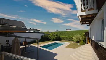 Weitläufiger Außenbereich mit Pool, Terrasse und Blick auf die umliegende Landschaft.