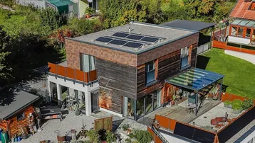 Moderne Architektur mit Flachdach, Photovoltaikanlage und gepflegtem Gartenbereich aus der Vogelperspektive.