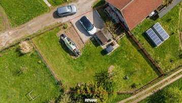Luftaufnahme des Grundstücks mit Haus, Garten und Photovoltaikanlage auf dem Dach.