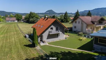 Freistehendes Einfamilienhaus mit rotem Ziegeldach und großem Garten in ländlicher Umgebung.