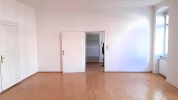 Heller, leerer Raum mit Parkettboden und weißen Wänden, bereit zur individuellen Gestaltung.