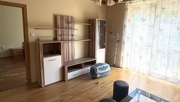 Helles Wohnzimmer mit Holzdeckenverkleidung, Parkettboden und einem modernen TV-Möbel.