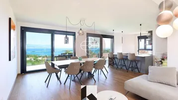 Heller Wohn- und Essbereich mit Meerblick, großen Schiebetüren und Zugang zur Terrasse.