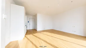 Heller, leerer Raum mit Holzboden und weißen Wänden, bereit für die individuelle Gestaltung.