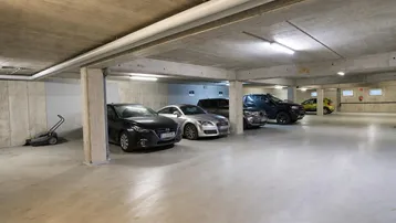 Geräumige Tiefgarage mit Betonwänden und -decken, ausreichend Platz für mehrere Fahrzeuge.