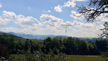 Weitläufiger Panoramablick auf die Berglandschaft mit dem Traunstein am Horizont.