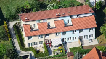 Luftaufnahme von Reihenhäusern mit Gärten und Terrassen in einer gepflegten Wohnsiedlung.
