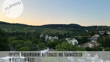 Panoramablick über Weinberge und die umliegende Landschaft bei Sonnenuntergang, mit Textüberlagerung.