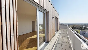 Geräumige Terrasse mit Holzelementen und weitem Blick über die Landschaft.