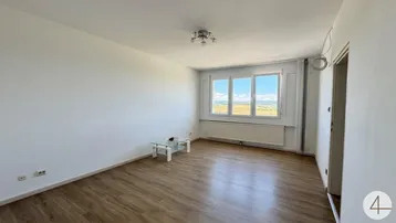 Geräumiges Wohnzimmer mit Laminatboden, großen Fenstern und weitem Ausblick.
