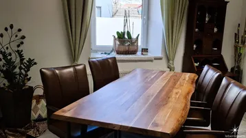 Geräumiger Essbereich mit einem großen Holztisch und bequemen Lederstühlen, ideal für gemeinsame Mahlzeiten.