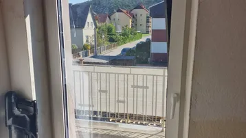 Fenster mit weitem Blick auf die umliegende Wohngegend und Hügellandschaft.