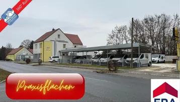 Außenansicht des Gebäudes mit Carport und Parkplätzen, umgeben von einer ländlichen Umgebung.