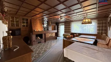 Gemütlicher Wohn- und Essbereich mit Kamin, Holzmöbeln und einer Kassettendecke.