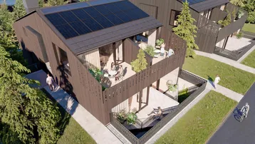 Moderne Häuser mit Holzfassade, Solaranlagen auf dem Dach und mehreren Balkonen.