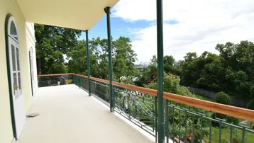 Geräumiger Balkon mit schmiedeeisernem Geländer und weitem Blick ins Grüne.