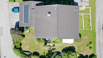Senkrechte Luftaufnahme des Hauses mit Dach, Garten und angrenzenden Grundstücken.