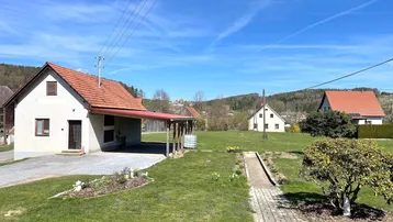 Großzügiger Gartenbereich mit Rasenfläche, Wegen und ländlichem Ausblick.