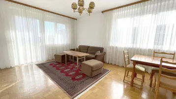 Heller Wohn- und Essbereich mit Parkettboden, bequemer Couch und Esstisch, ideal für gesellige Stunden.