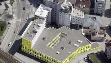 Luftaufnahme eines modernen Bürokomplexes mit markanter gelber Fassade und einem zentralen Innenhof.