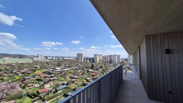 Geräumiger Balkon mit Fliesenboden und weitem Blick über die Stadt und Kleingärten.