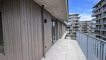 Geräumiger Balkon mit Fliesenboden und Blick auf die moderne Wohnanlage.