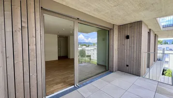 Geräumiger Balkon mit Fliesenboden und Schiebetüren, der einen weiten Blick auf die Umgebung bietet.