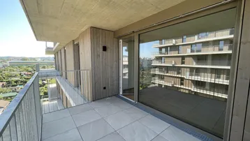 Geräumiger Balkon mit Fliesenboden und Blick auf die Umgebung, ideal für entspannte Stunden im Freien.
