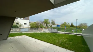 Geräumige Terrasse mit direktem Zugang zum Rasen und Blick auf die Umgebung.