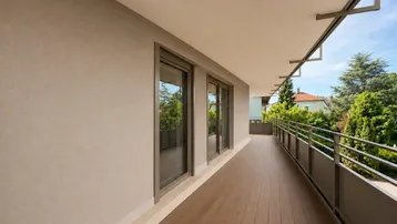 Langer Balkon mit Holzboden und Blick ins Grüne, ideal für Entspannung im Freien.