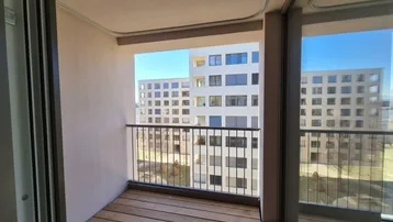 Kleiner Balkon mit Holzboden und Blick auf die umliegenden modernen Gebäude.
