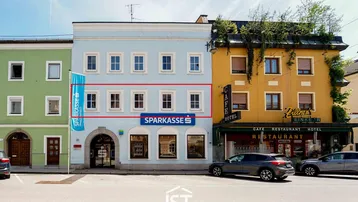 Außenansicht eines Geschäftsgebäudes mit roter Umrandung, die eine Etage hervorhebt.