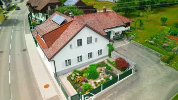 Luftaufnahme des Hauses mit rotem Ziegeldach, weißer Fassade und gepflegtem Vorgarten.