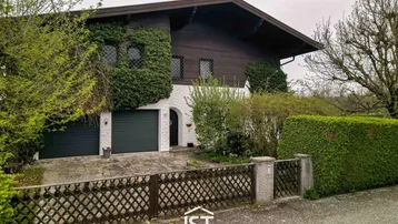 Traditionelles Haus mit begrüntem Giebel, Doppelgarage und gepflegtem Vorgarten.