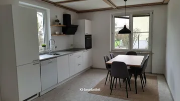 Helle Küche mit weißen Einbauschränken, Essbereich und Blick in den Garten.