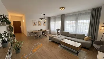 Geräumiger Wohn-Essbereich mit hellem Holzboden, bequemer Sitzecke und Esstisch für gesellige Stunden.