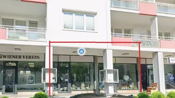 Ansicht der Geschäftsfassade eines modernen Gebäudes mit Balkonen und großen Schaufenstern im Erdgeschoss.