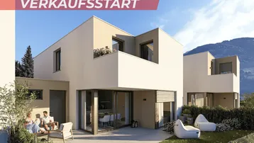 Moderne Architektur mit großzügiger Terrasse und Gartenbereich, umgeben von grüner Landschaft und Bergen.