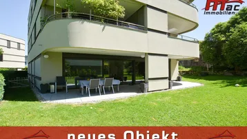Moderne Wohnanlage mit großer Terrasse und gepflegtem Rasen, ideal für entspannte Stunden im Freien.