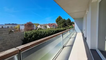 Langer Balkon mit Glasbrüstung und weitem Blick über die Umgebung.