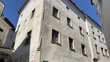 Historisches Gebäude mit aufwendiger Fassadenmalerei und traditioneller Architektur in einer Gasse.