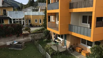 Außenansicht des Gebäudes mit Garten, Terrasse und Blick auf die umliegende Landschaft.