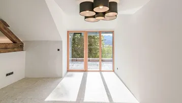 Lichtdurchfluteter Wohnbereich mit großen Fenstern, die einen weiten Blick nach draußen ermöglichen.