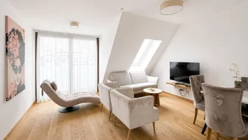 Helles Wohn- und Esszimmer mit Holzboden, Dachschrägen und Dachfenster, modern eingerichtet.
