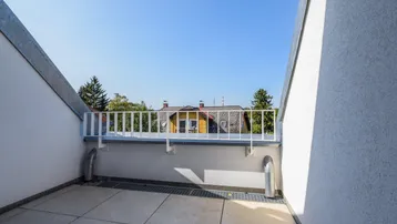 Kleiner Balkon mit Fliesenboden und Metallgeländer, bietet einen weiten Blick auf die Umgebung.