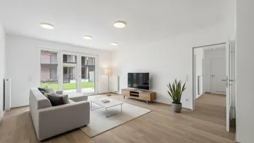 Helles, modern eingerichtetes Wohnzimmer mit Holzboden, Zugang zum Garten und Blick ins Grüne.